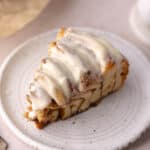 Giant cinnamon rolls cake slice sitting on a dessert plate, feature photo.