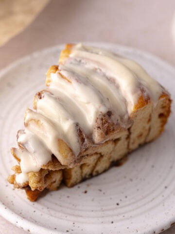 Giant cinnamon rolls cake slice sitting on a dessert plate, feature photo.