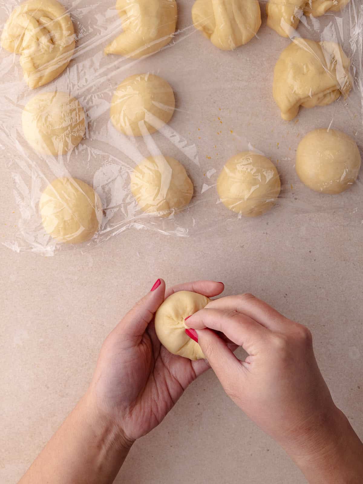 The ends of the flat dough are gathered together to form a ball.