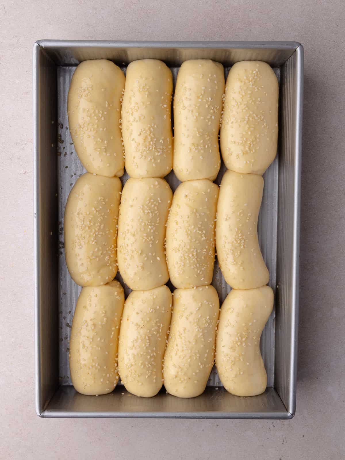 Mini brioche rolls have doubled in size and have got a light brushing of an egg wash and a sprinkling of sesame seeds.