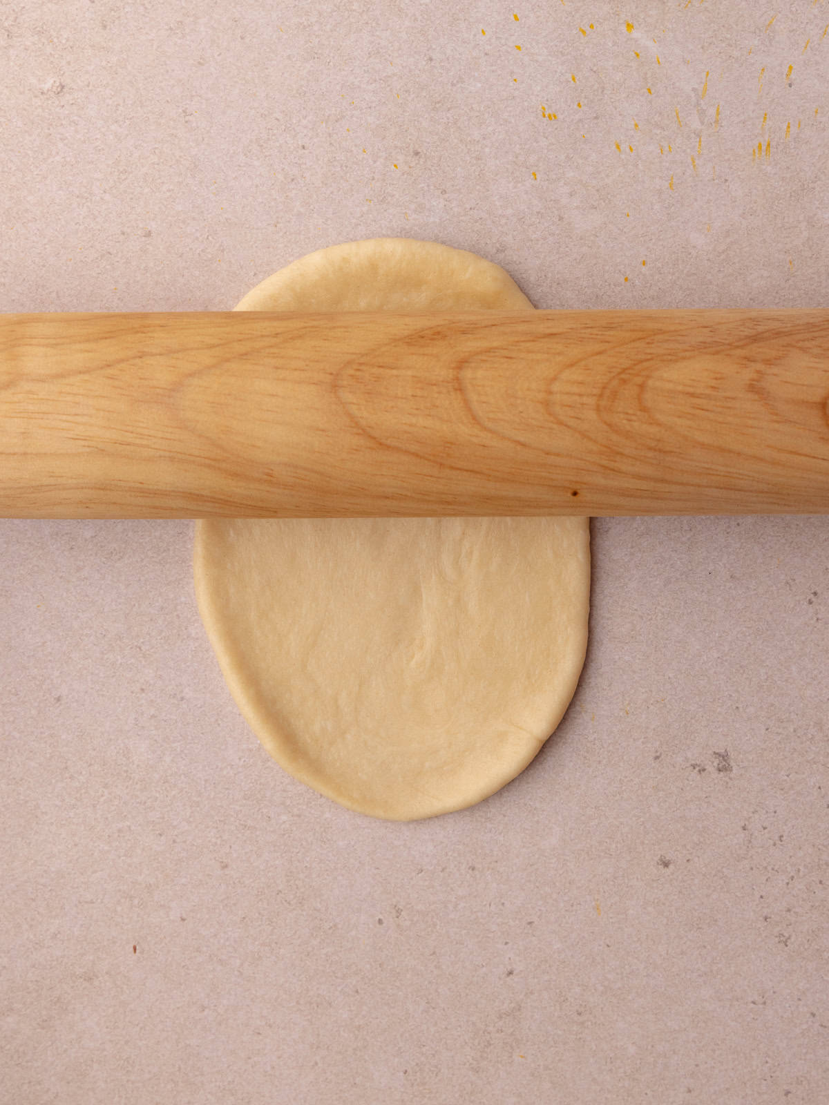 Each ball of dough is rolled flat.