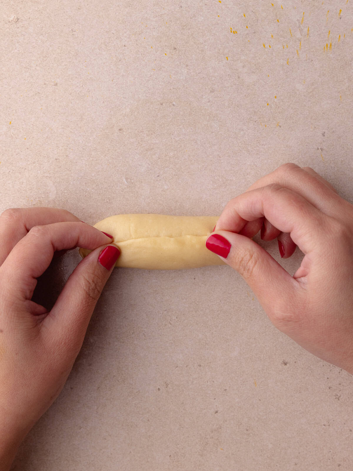 The dough is rolled tightly to form a log and then the seams are pinched together.