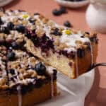 Blueberry lemon crumb cake slice in a cake server feature photo.