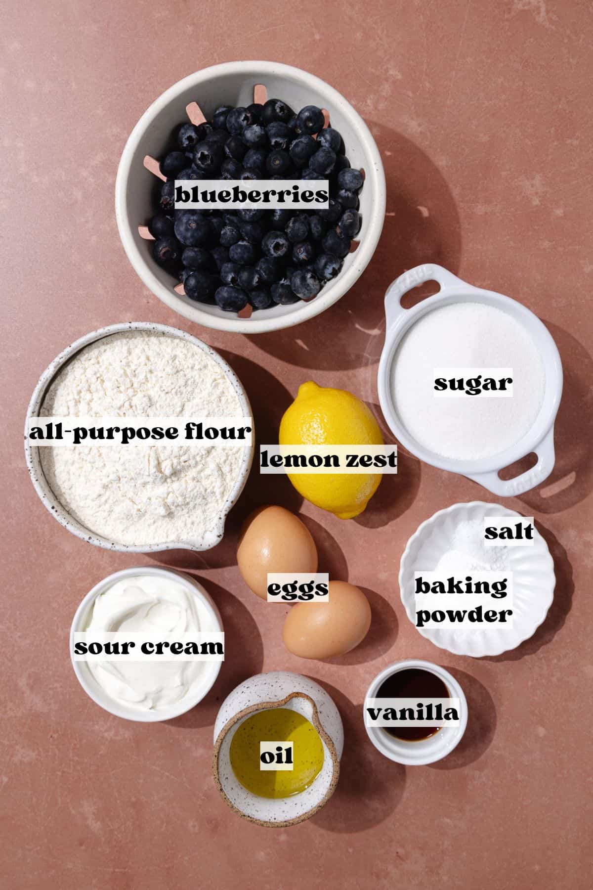 Blueberry lemon crumb cake ingredients which include, blueberries, flour, lemon zest, oil, sour cream, vanilla, sugar, eggs, baking powder and salt.