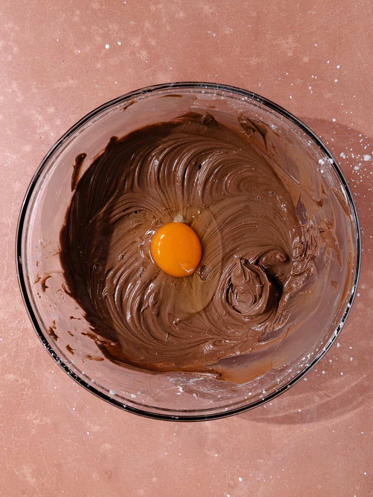 An egg is added to the cream cheese, cocoa powder and powdered sugar mixture.