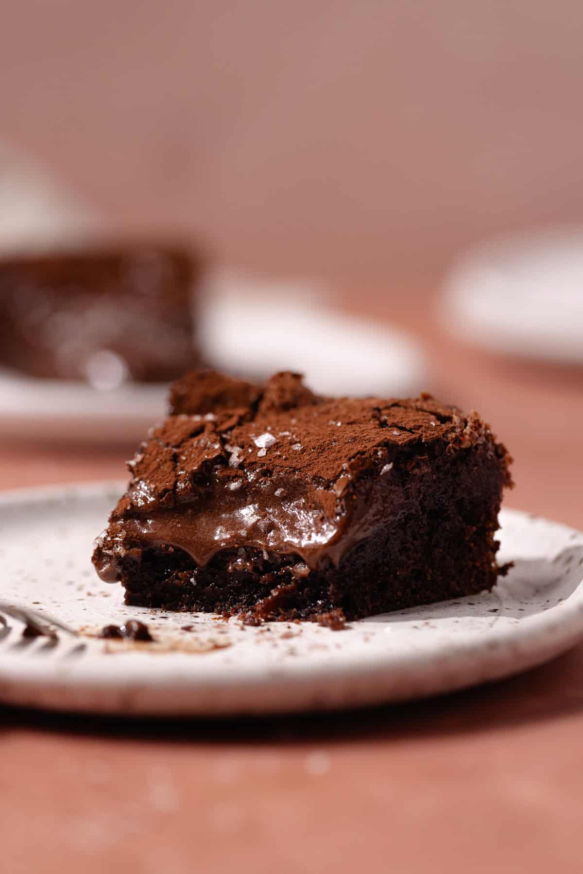 A slice of chocolate gooey butter cake on a dessert plate.