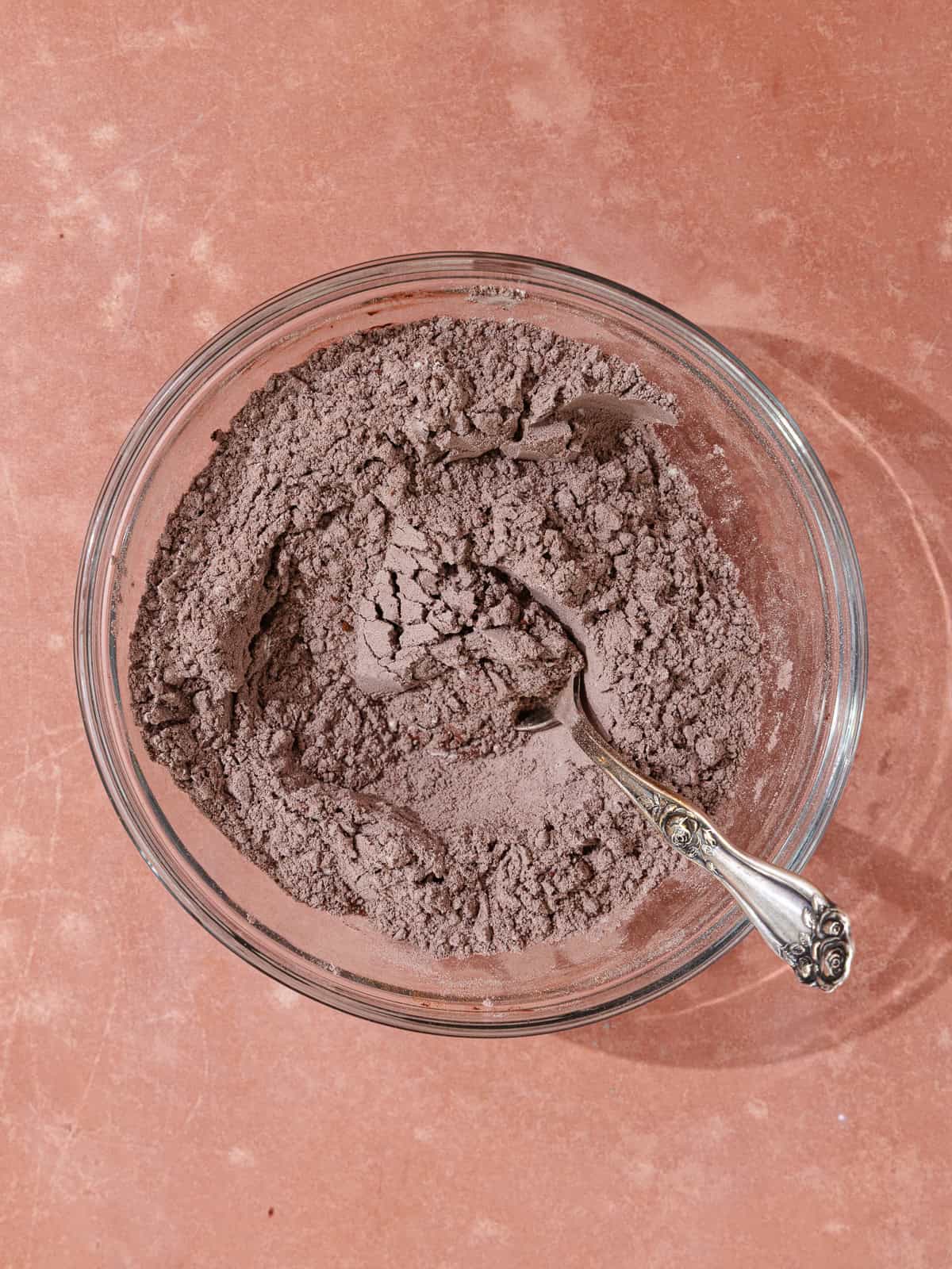 All-purpose flour, dutch-process cocoa powder, baking powder and salt are whisked together in a small glass bowl.