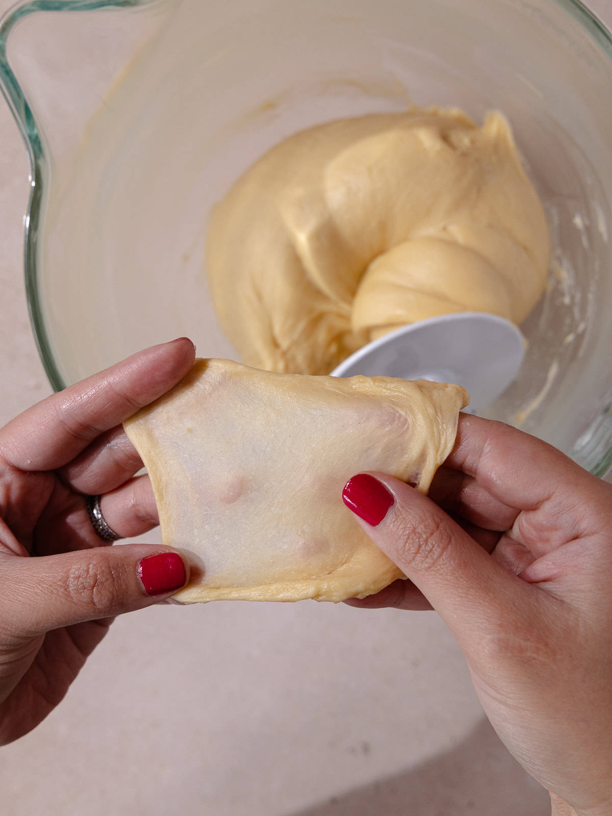 Window pane test is performed by stretching a small ball of dough.