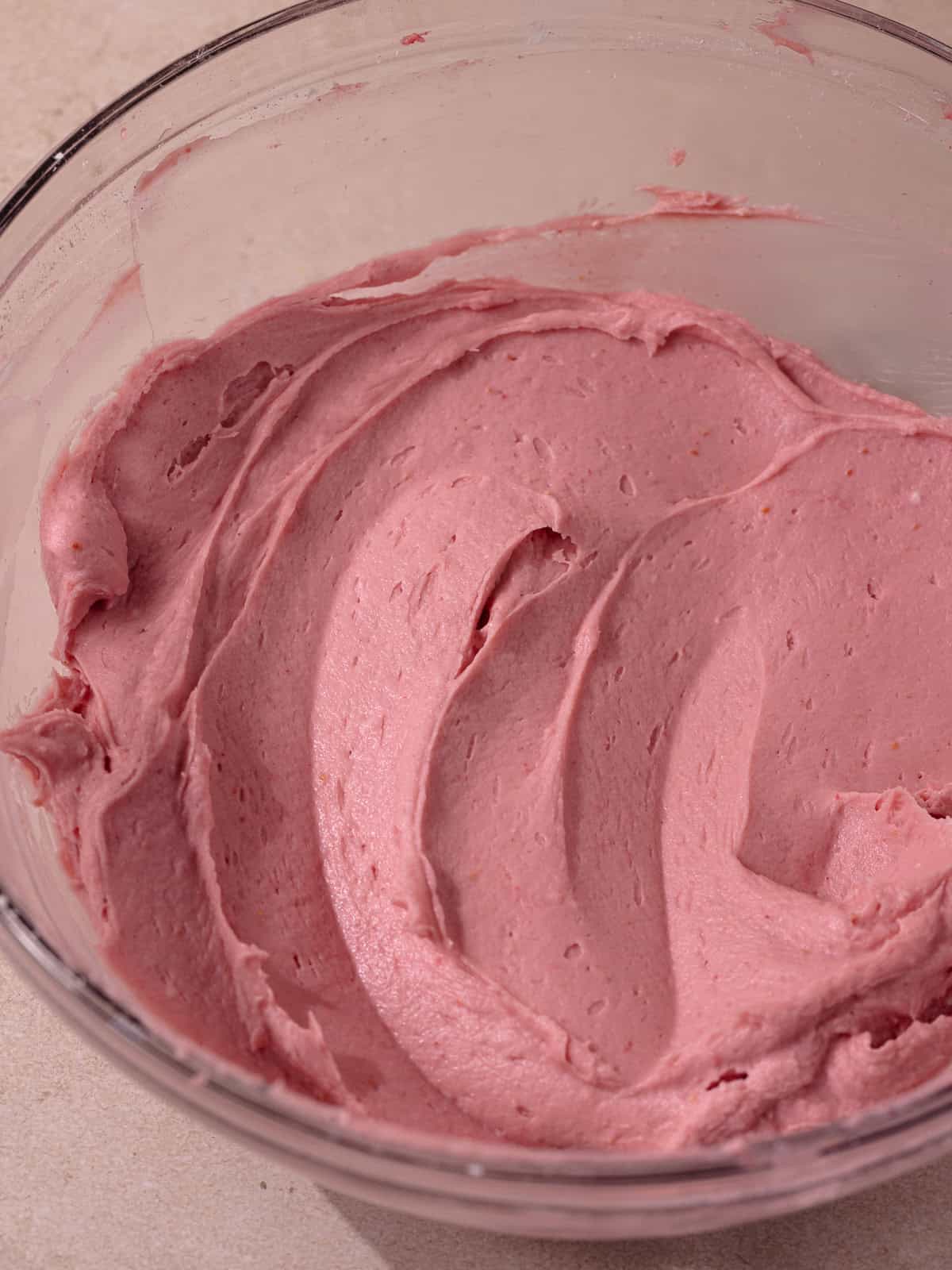 Raspberry cheesecake filling sitting in a glass bowl.