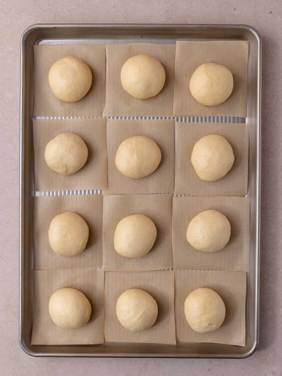 Balls of dough are sitting on a baking sheet.