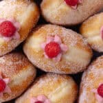 Raspberry cheesecake donuts sitting in a white baking dish feature photo.