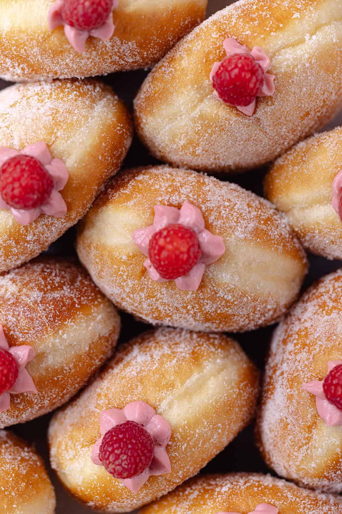 Raspberry cheesecake donuts sitting in a white baking dish.