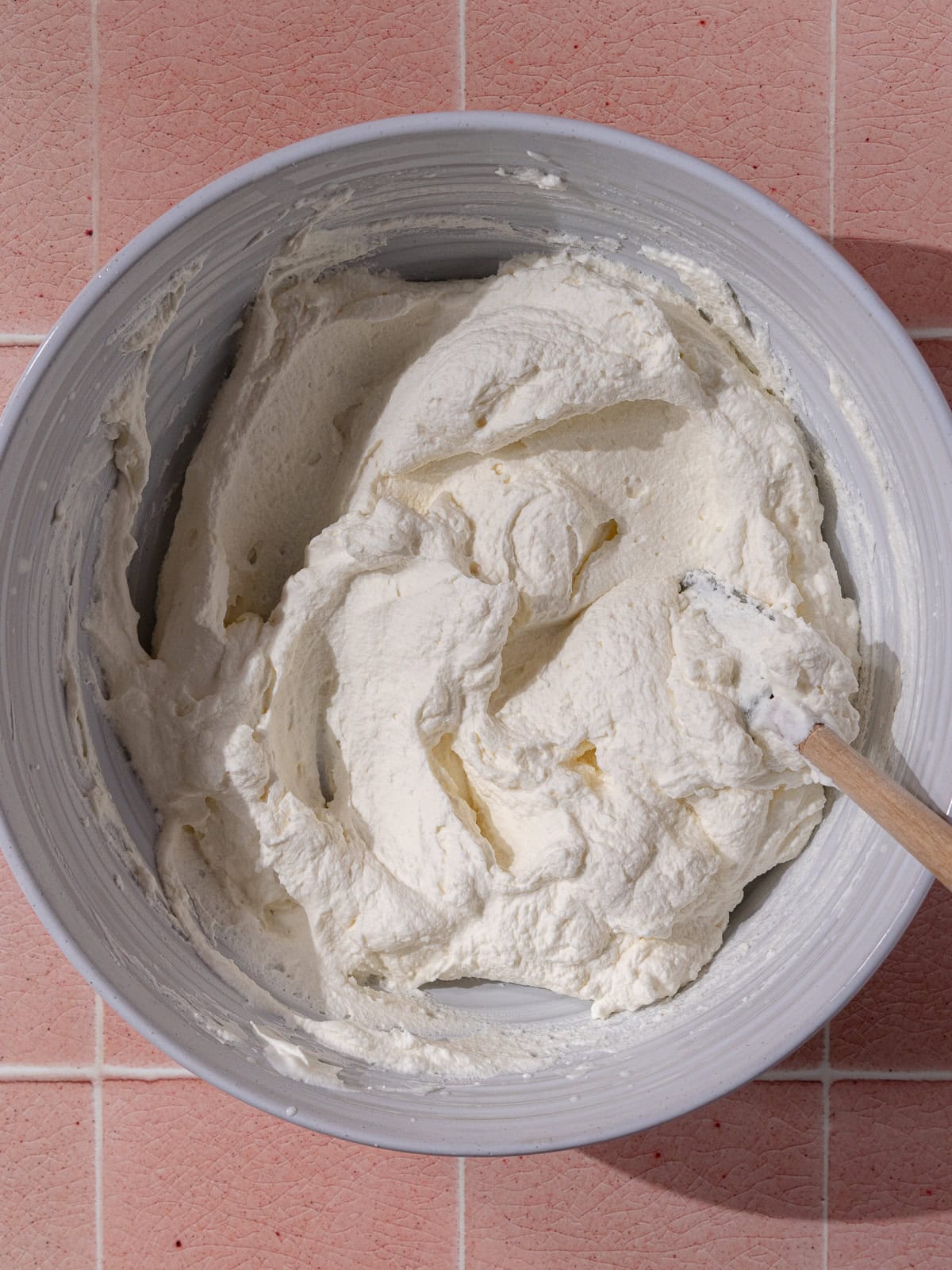 Vanilla whipped cream in a large white mixing bowl.