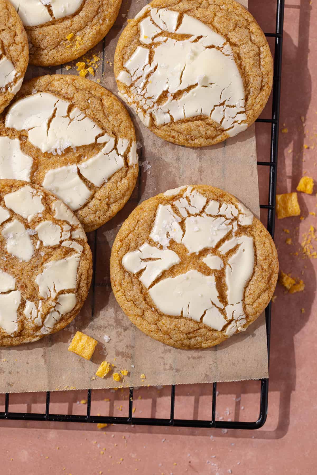 Captain Crunch cookies topped with white chocolate sitting on a wire rack.