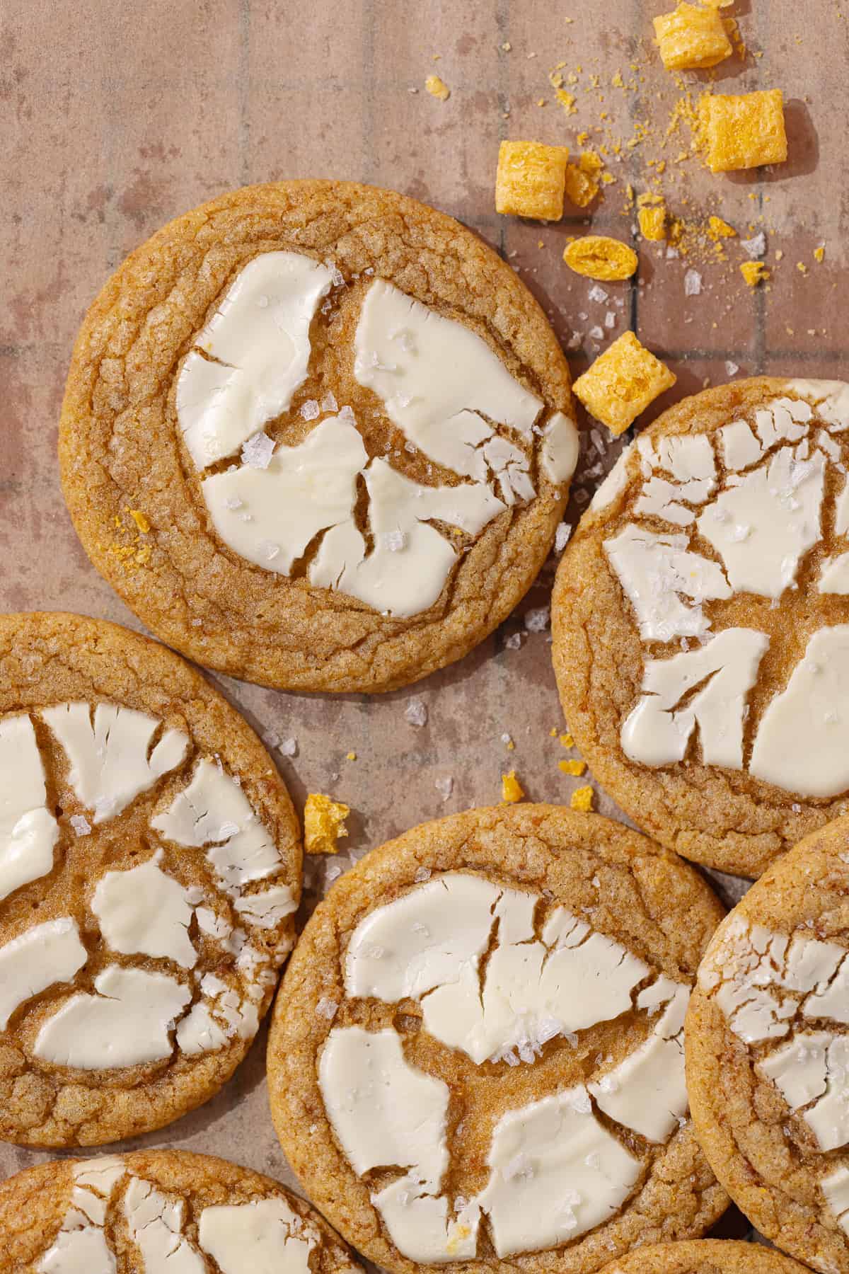 Captain Crunch cookies topped with white chocolate sitting on a wire rack.