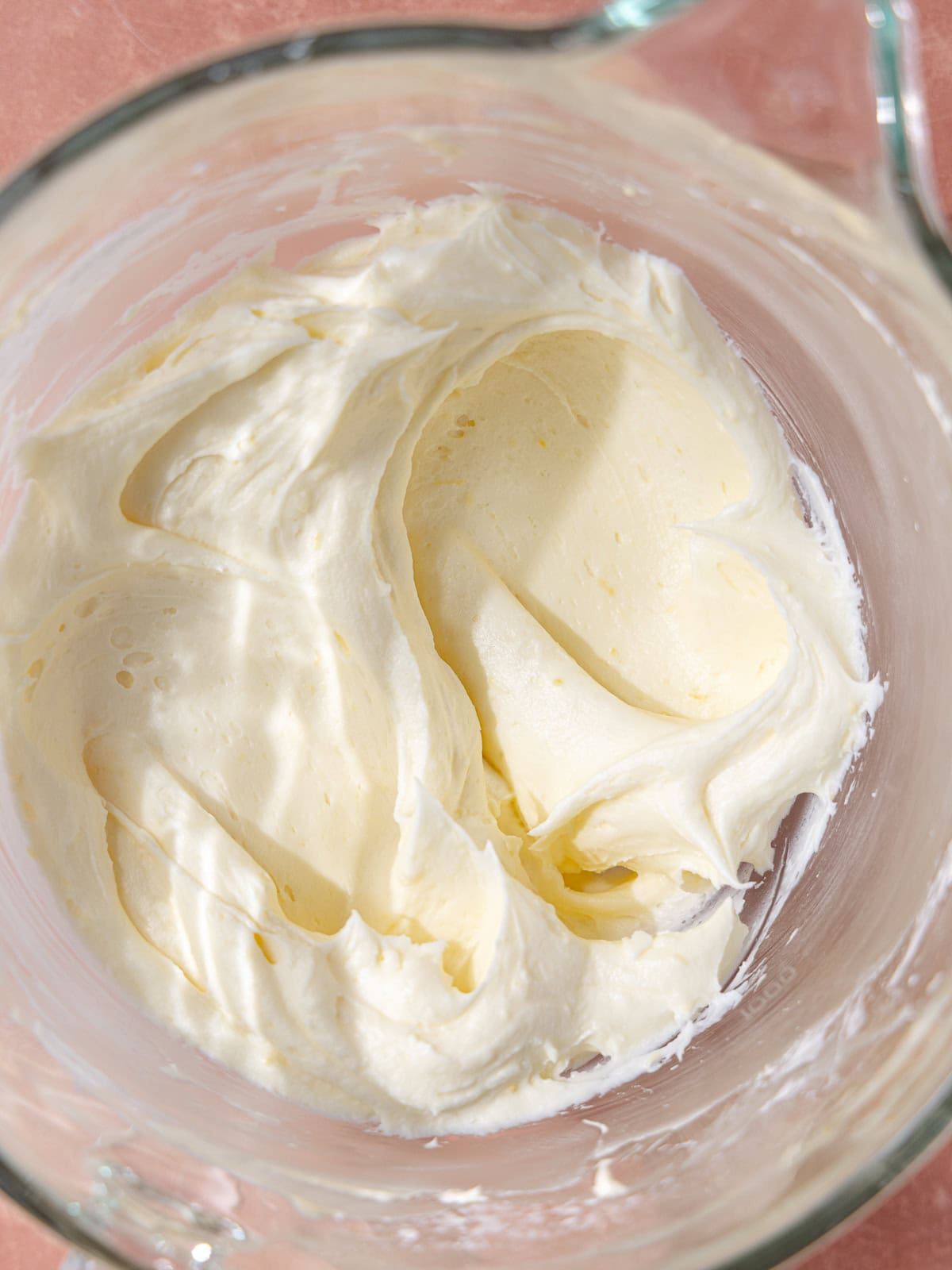 Lemon cream cheese frosting is in the stand mixer bowl.