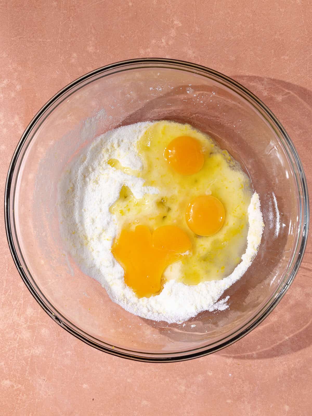 Sugar, lemon zest and eggs are in a large mixing bowl.